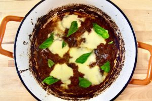 dutch oven with venison steaks and melted cheese