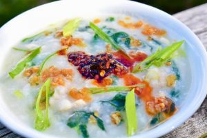 Bowl of fish congee with chili crisp